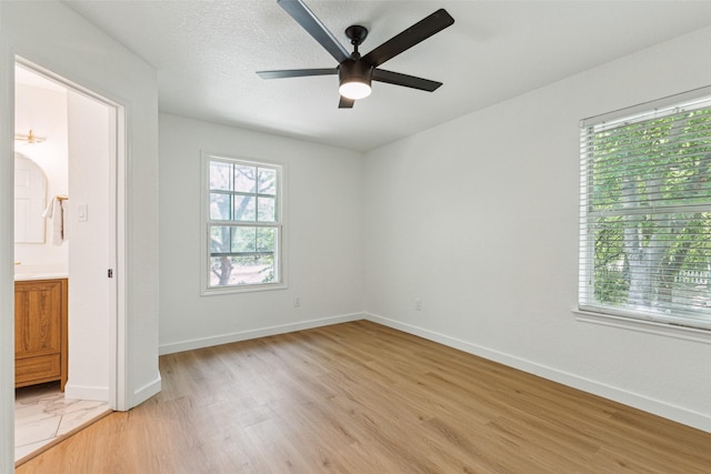 627 N Hampton Rd, Dallas, TX 75208 - unfurnished bedroom featuring light wood finished floors, baseboards, ensuite bathroom, and ceiling fan