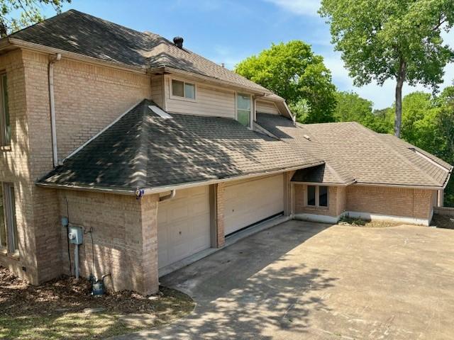 1417 Wyndmere Dr, Desoto, TX 75115 - view of property exterior with a shingled roof, brick siding, driveway, and an attached garage
