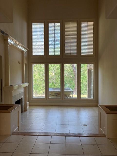 1417 Wyndmere Dr, Desoto, TX 75115 - unfurnished living room featuring light tile patterned floors, a fireplace, visible vents, and a towering ceiling
