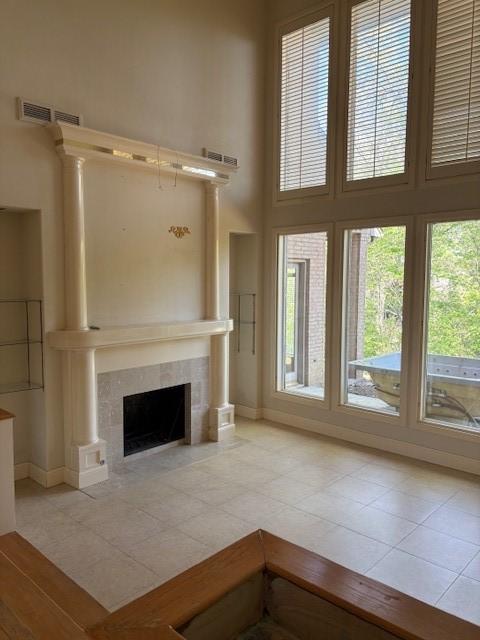 1417 Wyndmere Dr, Desoto, TX 75115 - unfurnished living room featuring visible vents, baseboards, a towering ceiling, and a tile fireplace
