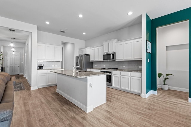 kitchen with tasteful backsplash, visible vents, appliances with stainless steel finishes, and white cabinetry