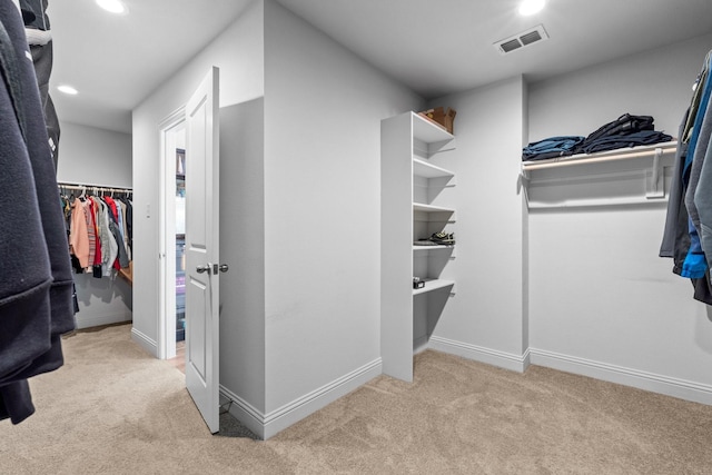 walk in closet featuring visible vents and carpet floors