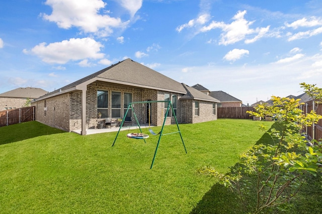 rear view of house with a yard, brick siding, a fenced backyard, and a patio