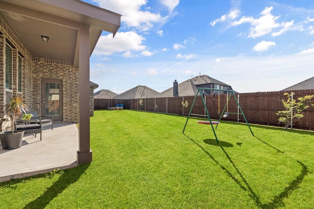 view of yard featuring a fenced backyard, a playground, and a patio