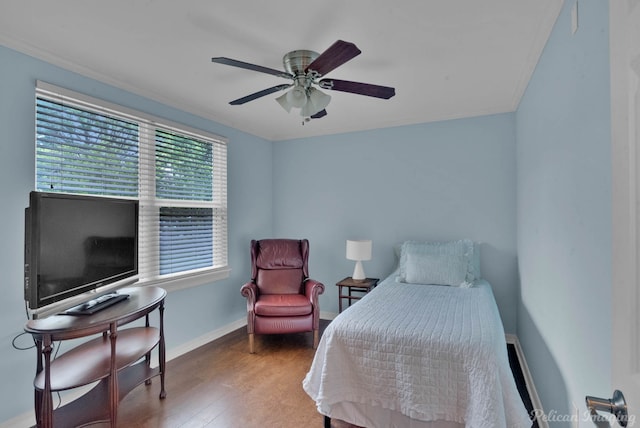 bedroom featuring a ceiling fan, wood finished floors, baseboards, and ornamental molding