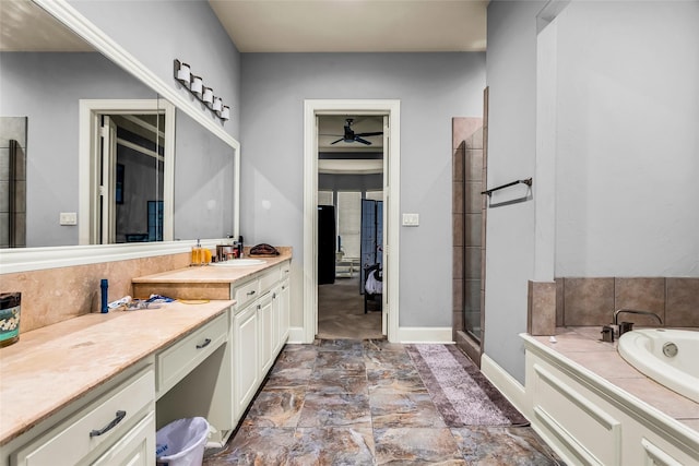 bathroom featuring a garden tub, a shower stall, vanity, a ceiling fan, and baseboards