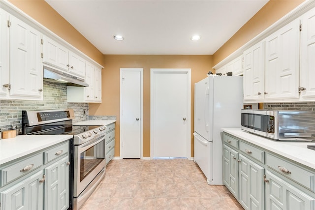 kitchen with white cabinetry, under cabinet range hood, light countertops, stainless steel appliances, and decorative backsplash