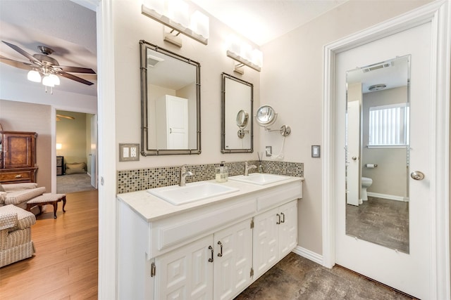 bathroom with a ceiling fan, visible vents, toilet, a sink, and double vanity