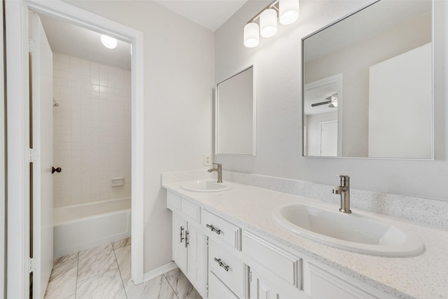 full bathroom with double vanity, marble finish floor, a sink, and shower / bathing tub combination