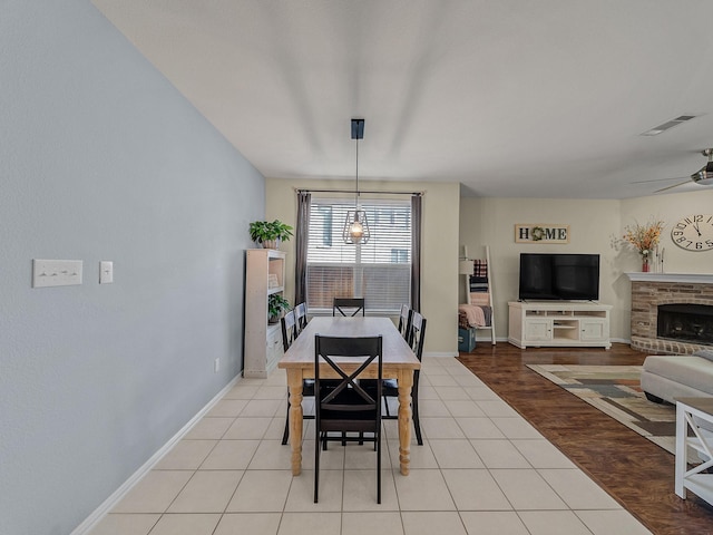 dining space with light tile patterned floors, visible vents, baseboards, and ceiling fan