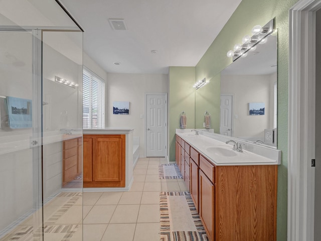 full bath with a stall shower, a garden tub, a sink, and tile patterned flooring