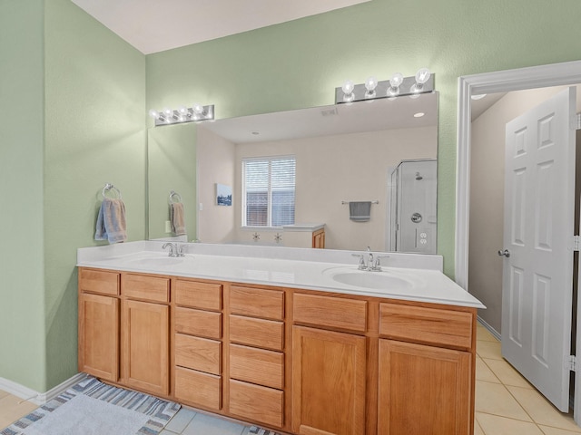 full bath featuring a shower stall, tile patterned flooring, double vanity, and a sink