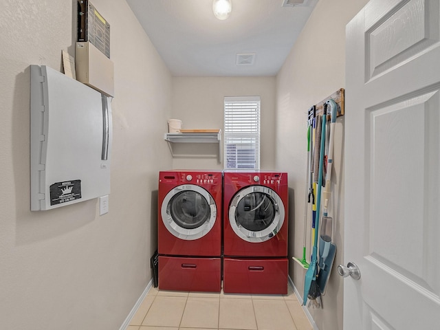 washroom featuring laundry area, tile patterned flooring, visible vents, washing machine and clothes dryer, and baseboards