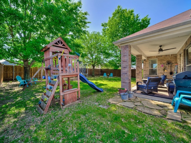 view of playground with a yard, a fenced backyard, a ceiling fan, and a patio
