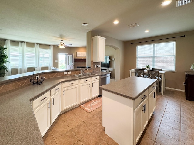kitchen featuring recessed lighting, ceiling fan, arched walkways, dishwasher, and a sink