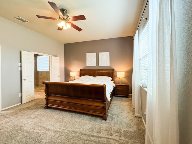 carpeted bedroom featuring visible vents, multiple windows, baseboards, and a ceiling fan