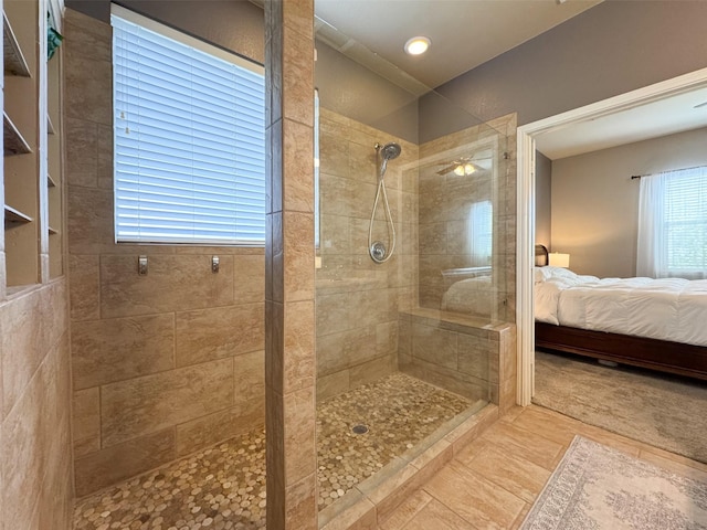 bathroom with ensuite bath, a tile shower, and ceiling fan