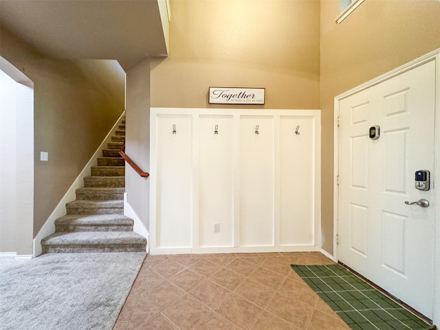 entrance foyer featuring light tile patterned floors and stairs