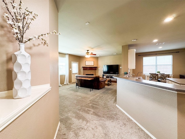 interior space featuring a fireplace, a ceiling fan, recessed lighting, a sink, and baseboards