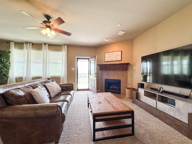 living room featuring visible vents, ceiling fan, carpet, and a fireplace