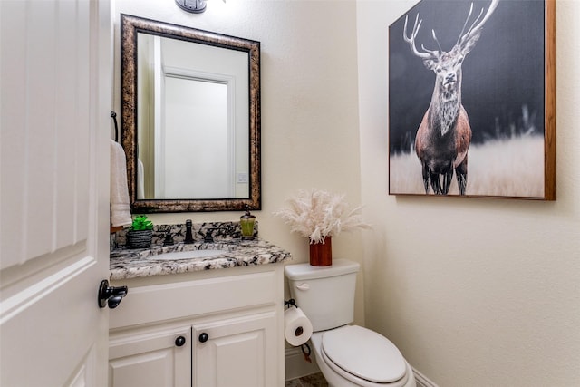 half bathroom featuring toilet and vanity