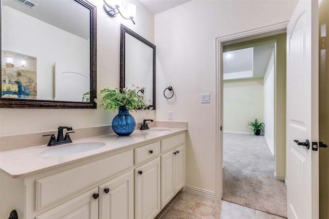 bathroom with baseboards, double vanity, and a sink