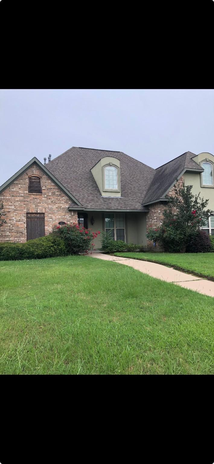 french provincial home with a front yard