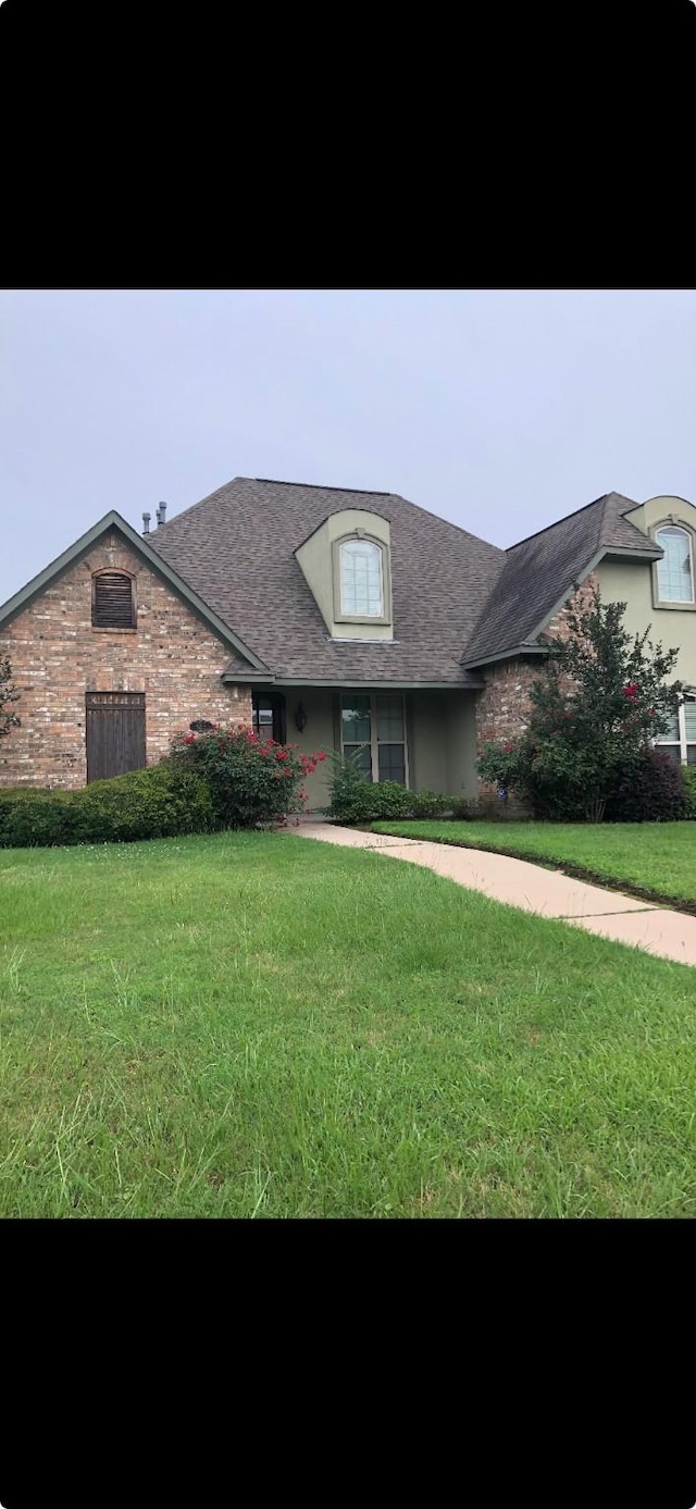 french provincial home with a front yard