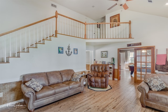 living area with high vaulted ceiling, ceiling fan, visible vents, stairway, and wood finished floors