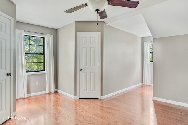 unfurnished bedroom with baseboards, a ceiling fan, and light wood-style floors