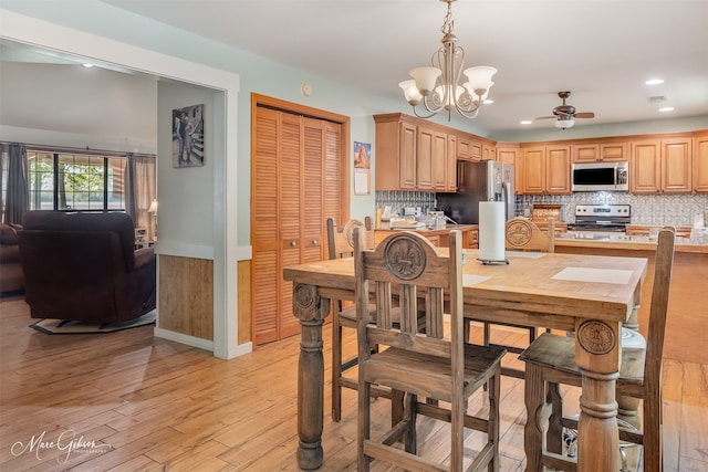 dining area featuring baseboards, recessed lighting, light wood-style floors, and ceiling fan with notable chandelier