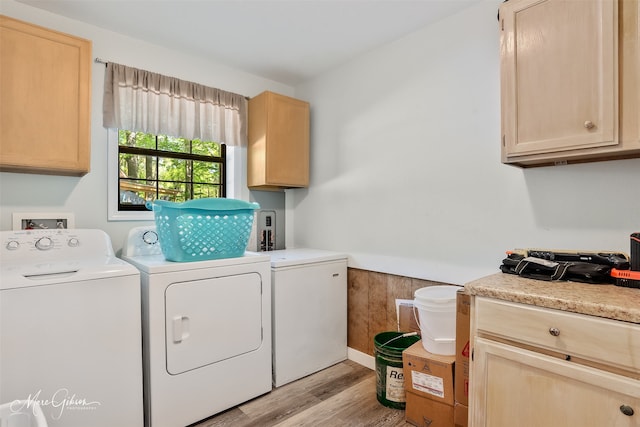 laundry room with light wood-style flooring, washing machine and clothes dryer, and cabinet space