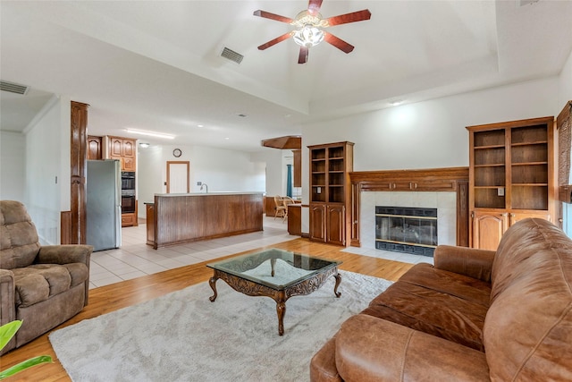 living area featuring ceiling fan, light wood finished floors, and visible vents