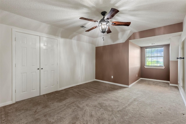 unfurnished bedroom with carpet flooring, a textured ceiling, visible vents, and a closet