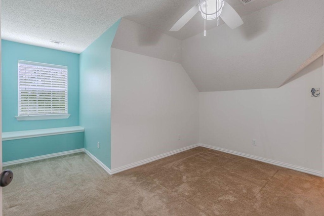 bonus room with carpet floors, lofted ceiling, baseboards, a textured ceiling, and a ceiling fan