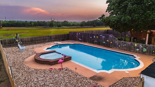 view of swimming pool with a diving board, a patio area, a pool with connected hot tub, and a fenced backyard