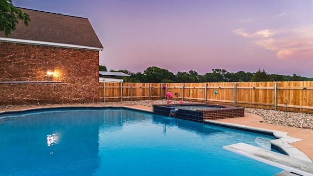 view of pool with a fenced backyard, a diving board, and a pool with connected hot tub