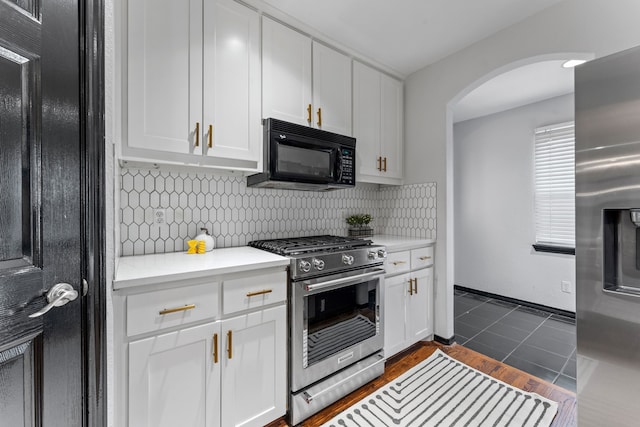 kitchen featuring appliances with stainless steel finishes, light countertops, white cabinetry, and backsplash