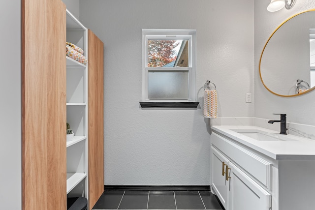 bathroom with tile patterned floors, vanity, and a textured wall