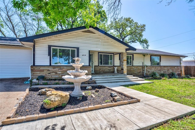 110 Pine St, Weatherford, TX 76086 - view of front of property with a shingled roof, stone siding, fence, and a front lawn