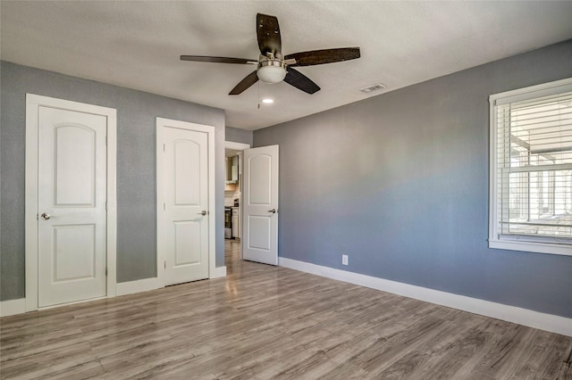 110 Pine St, Weatherford, TX 76086 - unfurnished bedroom featuring visible vents, baseboards, a ceiling fan, and wood finished floors
