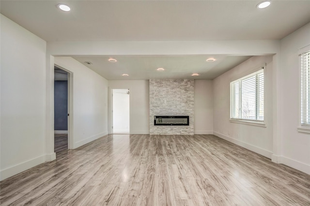 110 Pine St, Weatherford, TX 76086 - unfurnished living room with a stone fireplace, baseboards, recessed lighting, and wood finished floors