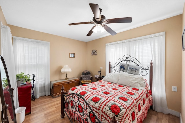 bedroom featuring baseboards, a ceiling fan, and light wood-style floors