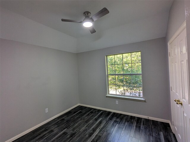 empty room featuring dark wood finished floors, baseboards, and ceiling fan