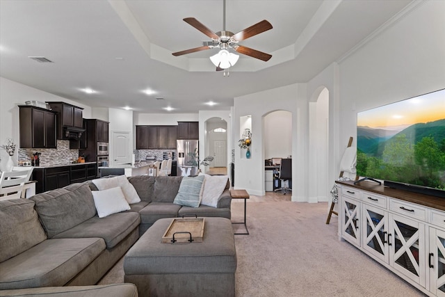 525 Northwood Dr, Oak Point, TX 75068 - living room with arched walkways, a tray ceiling, a ceiling fan, light carpet, and baseboards