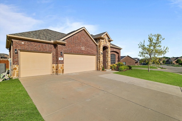 525 Northwood Dr, Oak Point, TX 75068 - view of front facade featuring concrete driveway, a garage, a front lawn, roof with shingles, and stone siding