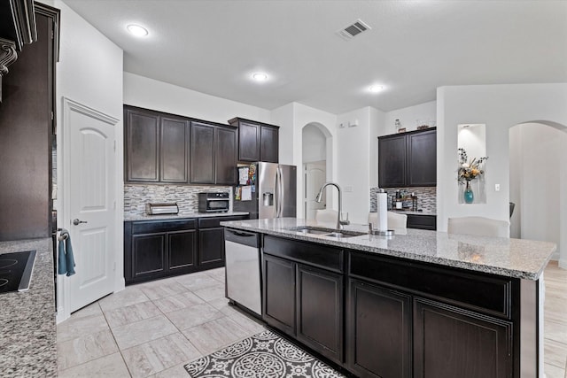 525 Northwood Dr, Oak Point, TX 75068 - kitchen featuring stainless steel appliances, arched walkways, a sink, backsplash, and recessed lighting