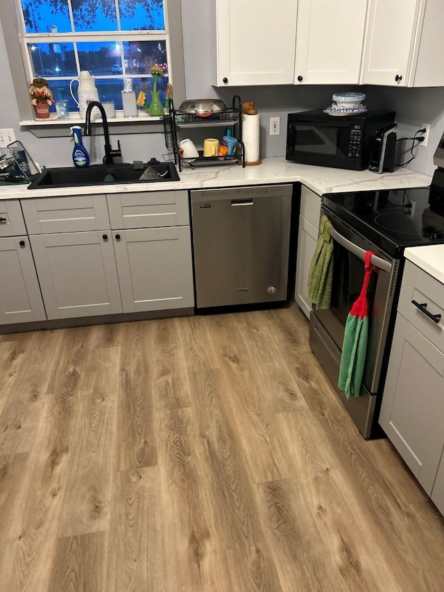 330 W Quitman St, Emory, TX 75440 - kitchen featuring stainless steel appliances, light wood finished floors, light countertops, and gray cabinetry