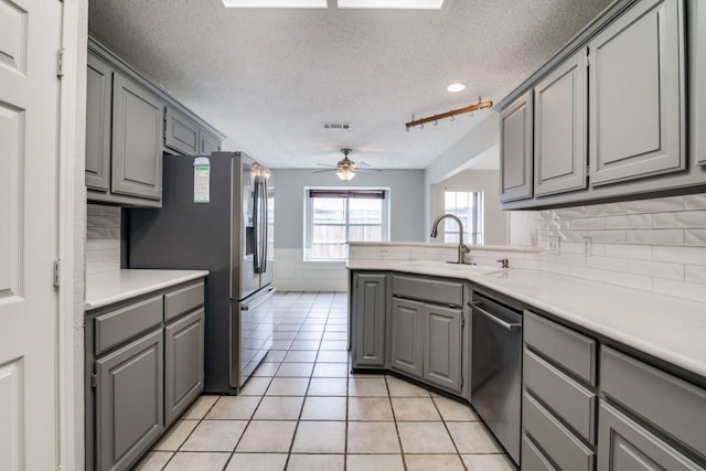 511 Windsor Way, Rockwall, TX 75087 - kitchen featuring gray cabinetry, appliances with stainless steel finishes, a textured ceiling, a sink, and a ceiling fan