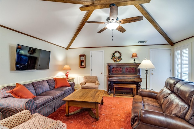 living area featuring a decorative wall, ceiling fan, lofted ceiling with beams, visible vents, and wainscoting